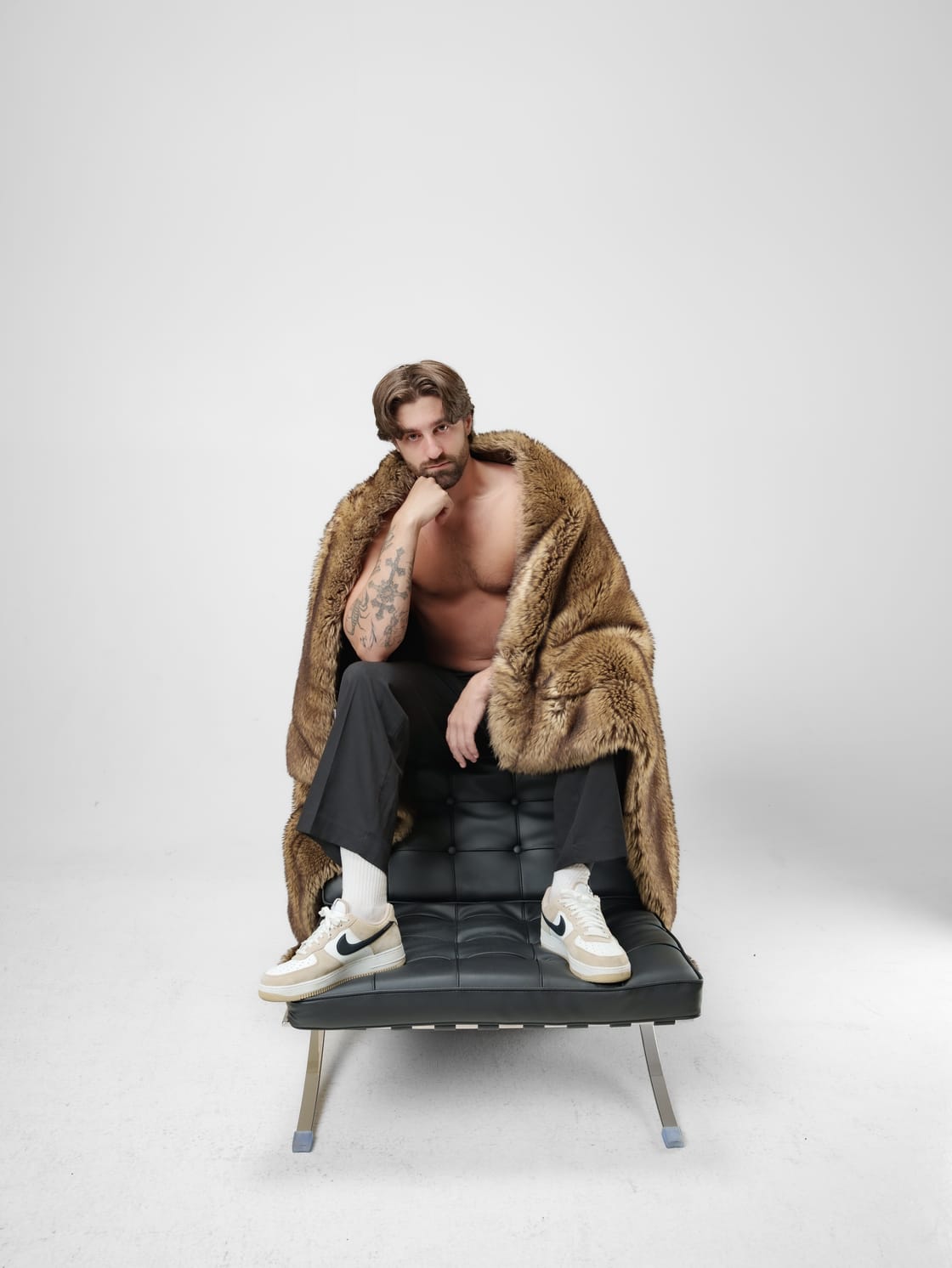 Studio fashion portrait of a seated model.