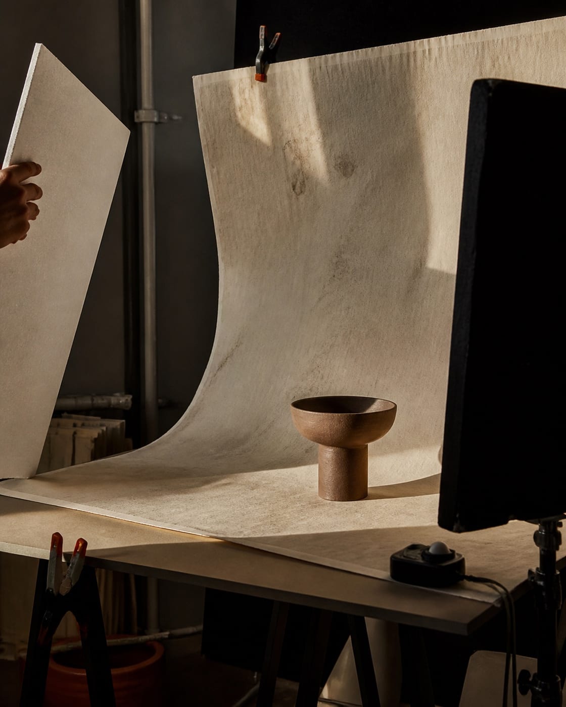 Editorial campaign concept showing a still-life set behind a studio monitor.