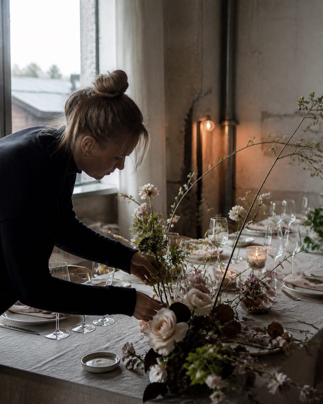 Editorial wedding concept of a florist preparing a table setting.